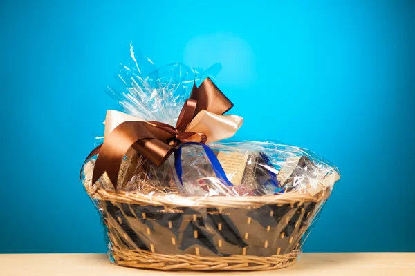 Gift in a basket against blue background — Stock Photo, Image
