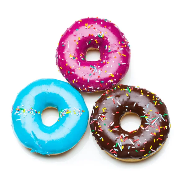 Три цвета пончики, изолированные на белом — стоковое фото