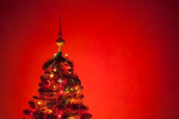 Árbol de Navidad con iluminación, fondo rojo —  Fotos de Stock