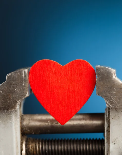 Red heart in the vice tool — Stock Photo, Image