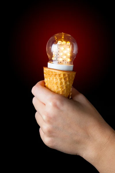 Hand holding led lamp in ice cream cone, innovation concept — Stock Photo, Image