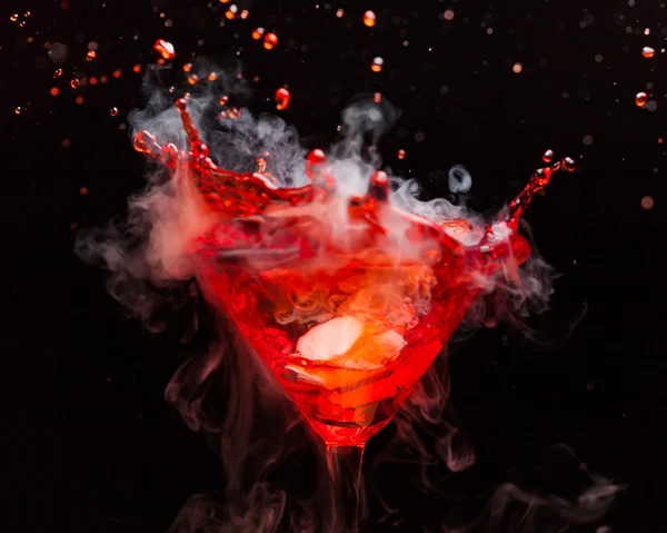 Cocktail vermelho com respingo e vapor de gelo — Fotografia de Stock