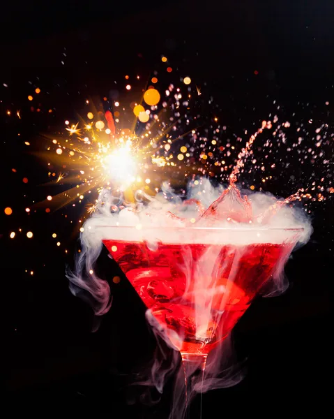 Red cocktail with splash, sparkler and ice vapor — Stock Photo, Image