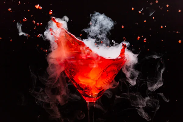 Cocktail rosso con spruzzi e vapore di ghiaccio — Foto Stock