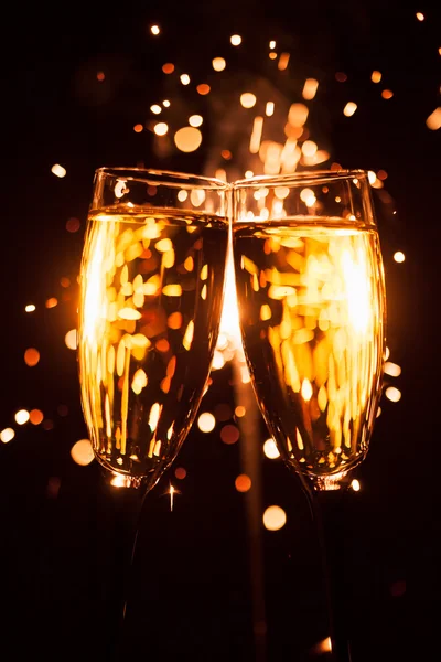 Champagnerglas vor weihnachtlichem Wunderkerzen-Hintergrund — Stockfoto