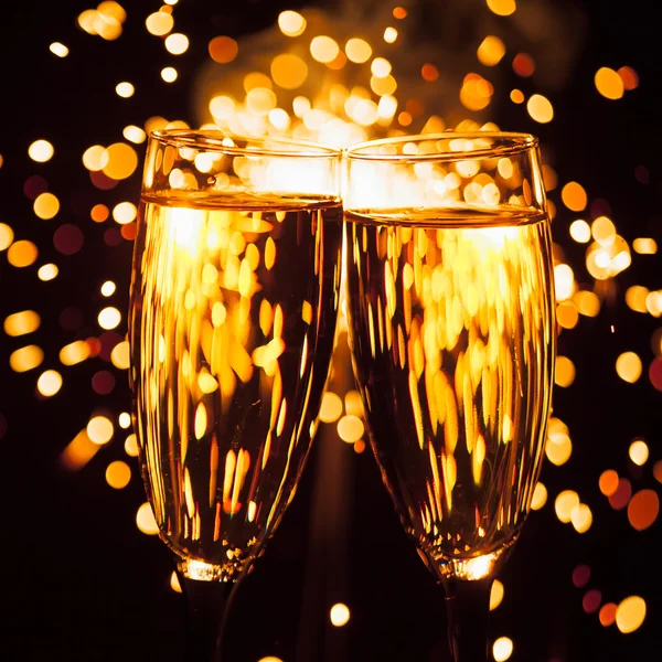 Champagnerglas vor weihnachtlichem Wunderkerzen-Hintergrund — Stockfoto