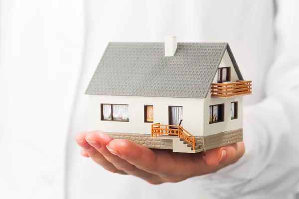 Miniatyr hus på hand, vit bakgrund — Stockfoto