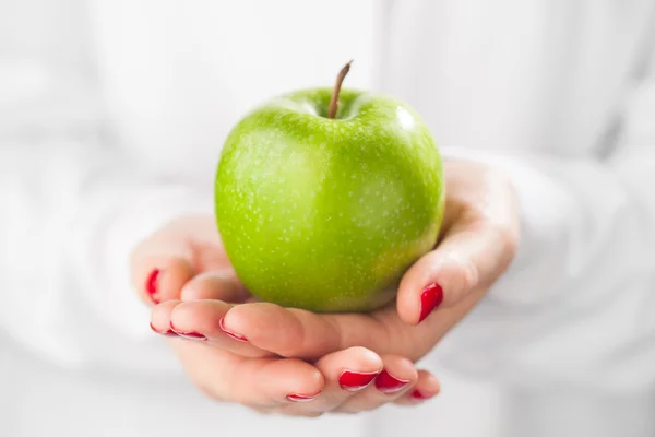 Zelené jablko v ruce, bílé pozadí — Stock fotografie