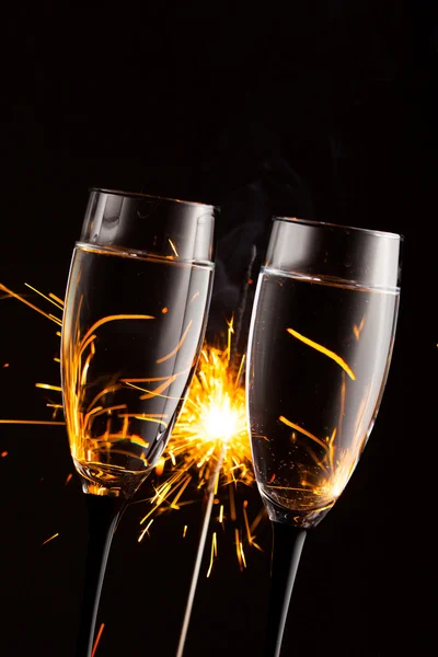 Champagne glasses against christmas sparkler background — Stock Photo, Image