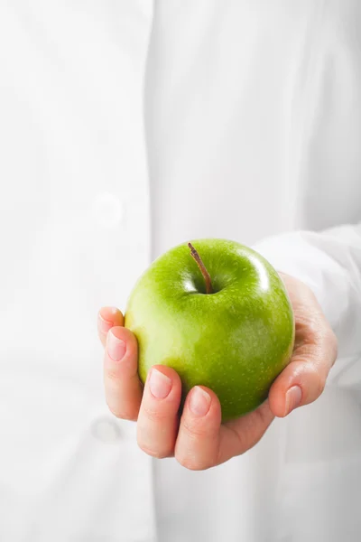 Groene appel in de hand, witte achtergrond — Stockfoto