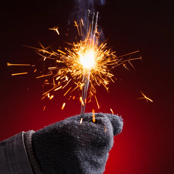 Sparkler in hand mitten — Stock Photo, Image