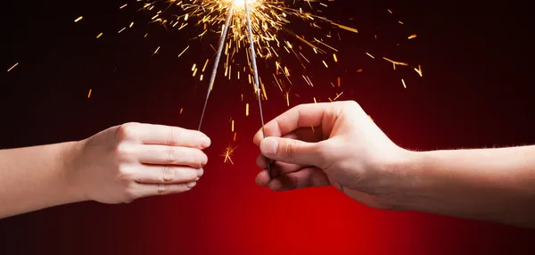 Sparklers in hands — Stock Photo, Image