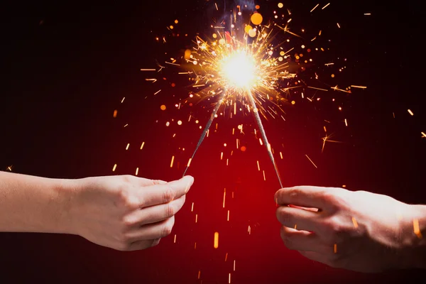 Sparklers in hands — Stock Photo, Image