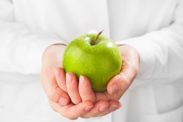 Manzana verde en las manos, fondo blanco — Foto de Stock