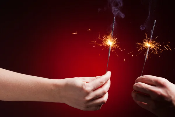 Sparklers in hands — Stock Photo, Image