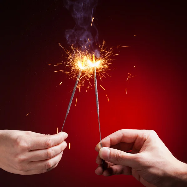 Sparklers in hands — Stock Photo, Image