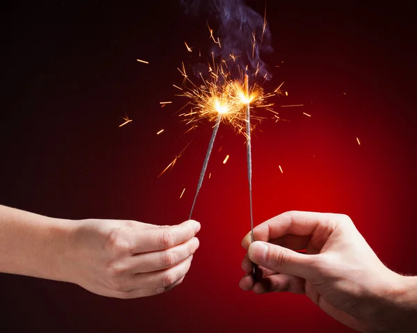 Sparklers in hands — Stock Photo, Image