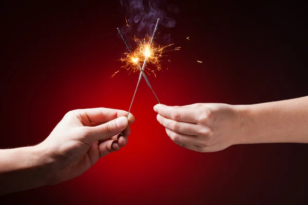 Sparklers in hands — Stock Photo, Image