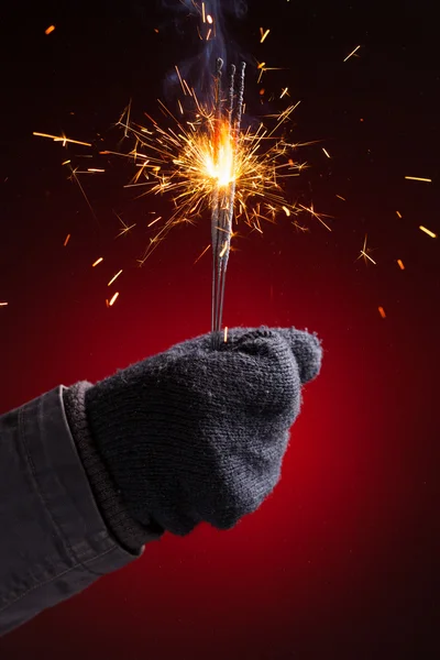 Sparkler in hand mitten — Stock Photo, Image