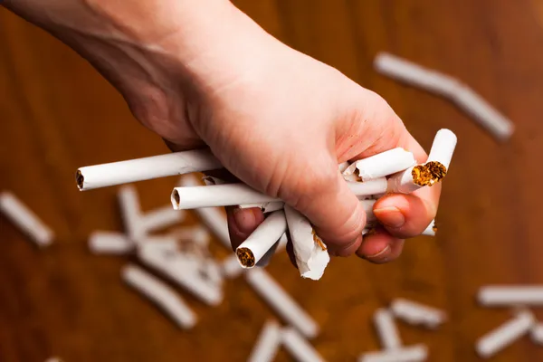 Mãos quebrando um cigarro — Fotografia de Stock