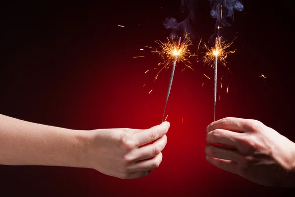 Sparklers in hands — Stock Photo, Image