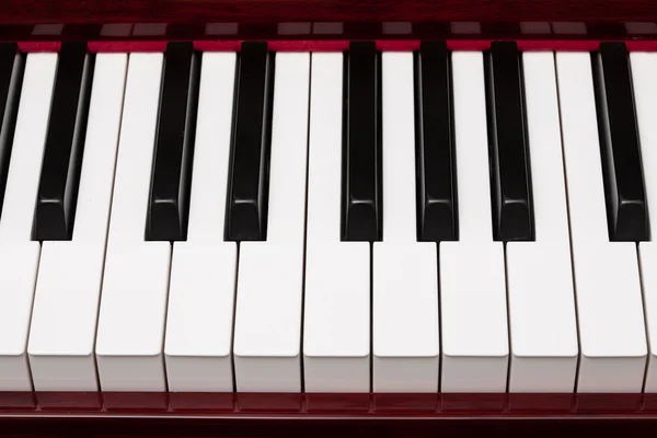Ébano e marfim chaves de piano vermelho — Fotografia de Stock