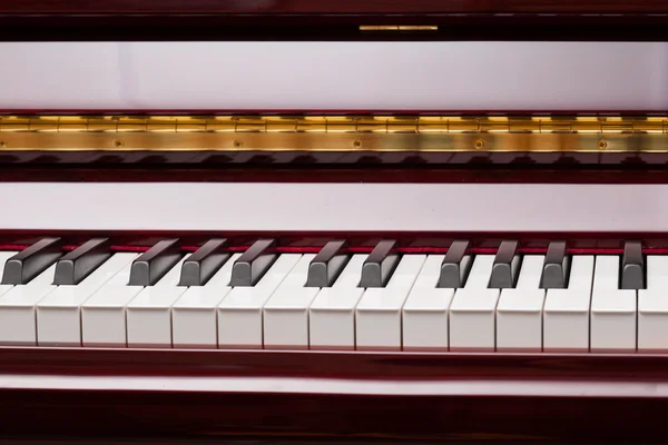 Ebony and ivory keys of red piano — Stock Photo, Image