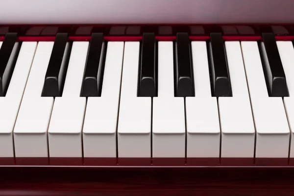 Ebony and ivory keys of red piano — Stock Photo, Image