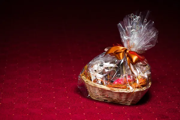 Gift basket against red background — Stock Photo, Image