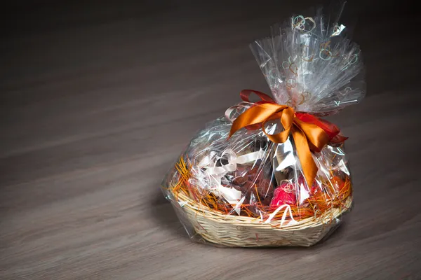 Gift basket against wooden background — Stock Photo, Image