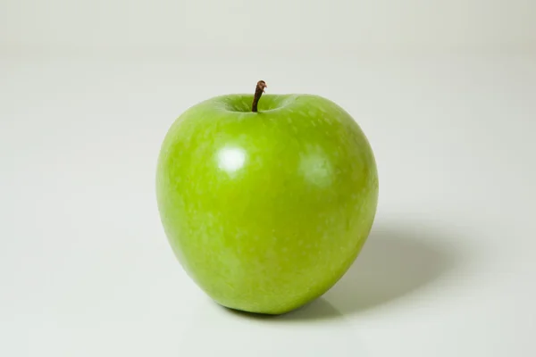 Бабуся котяче зелене яблуко на білому тлі — стокове фото