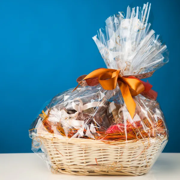 Gift basket against blue background — Stock Photo, Image