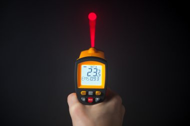 infrared laser thermometer in hand clipart