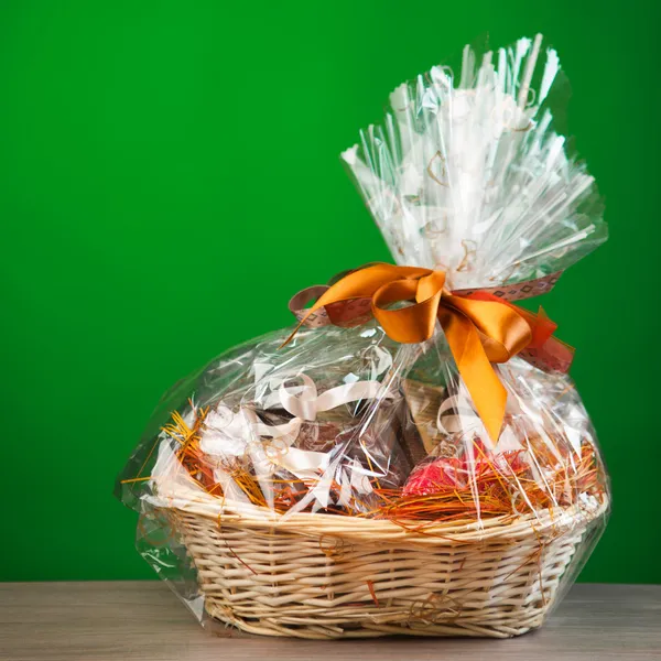 Geschenkkorb vor grünem Hintergrund — Stockfoto