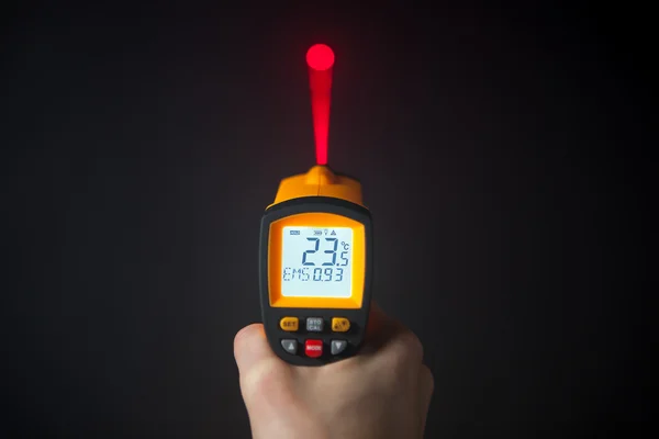 Infrared laser thermometer in hand — Stock Photo, Image