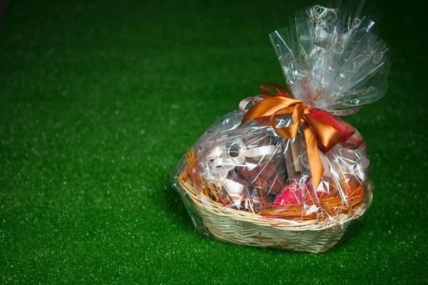 Gift basket against green lawn background — Stock Photo, Image