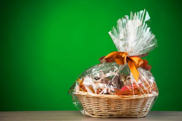 Gift basket against green background — Stock Photo, Image
