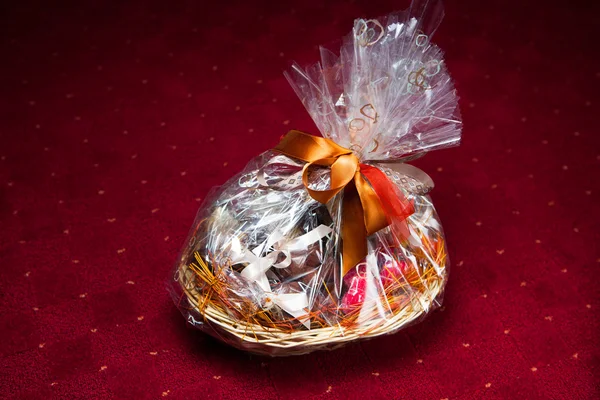 Gift basket against red background — Stock Photo, Image