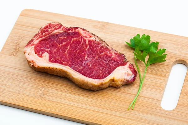 Fresh marbled meat on a wooden hardboard — Stock Photo, Image