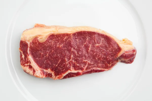 Свежее мраморное мясо на тарелке — стоковое фото