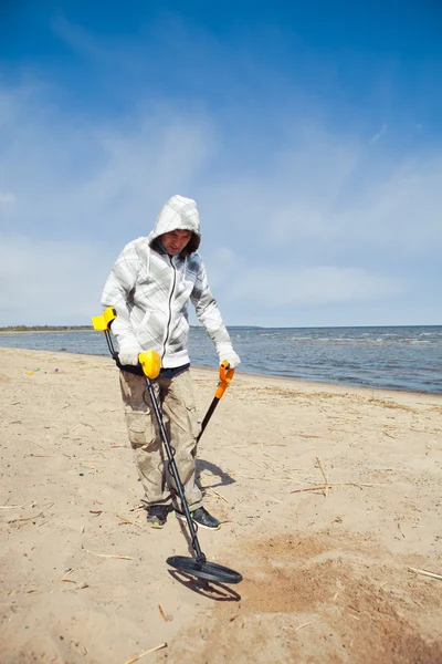 Hombre que busca un metal precioso usando un detector de metales —  Fotos de Stock