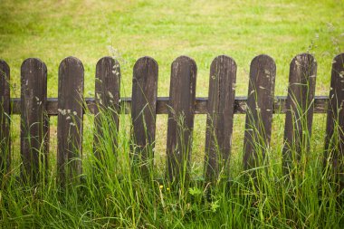 village decorative fence against green lawn background