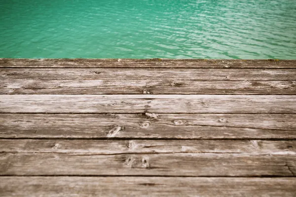Leeftijd houten pier achtergrond met water — Stockfoto