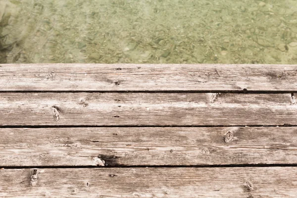 Leeftijd houten pier achtergrond met water — Stockfoto
