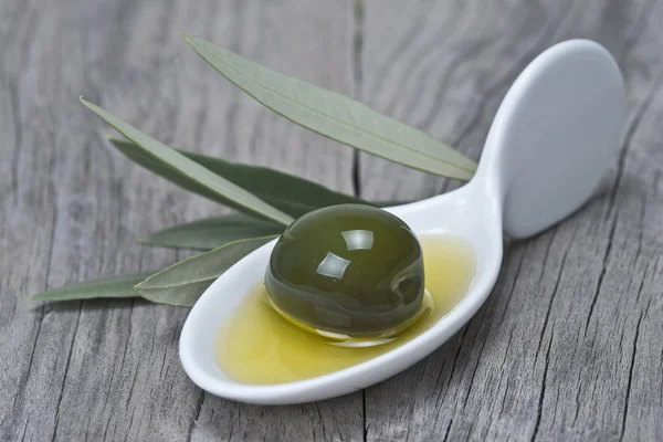 Porzellanlöffel mit einer Olive und Öl — Stockfoto