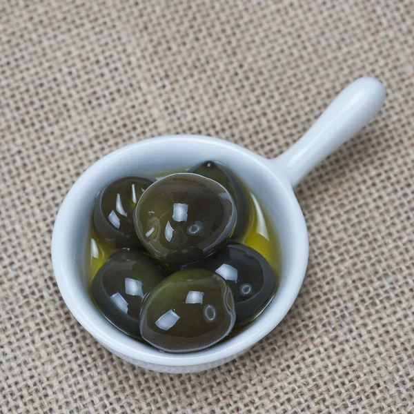 Saucer with olives on a burlap — Stock Photo, Image