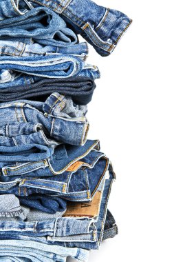beyaz zemin üzerinde mavi jeans yığını