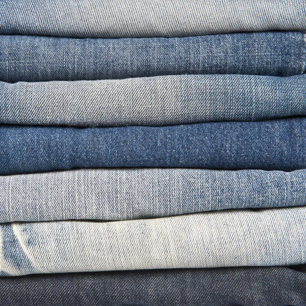 Stack of different old worn blue jeans — Stock Photo, Image