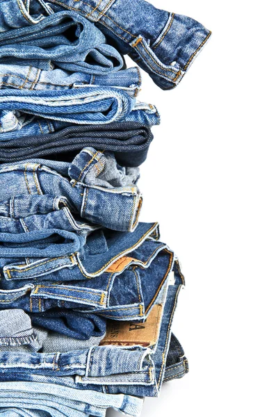 Stapel blauer Jeans vor weißem Hintergrund — Stockfoto