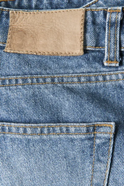 Jeans with empty leather label — Stock Photo, Image